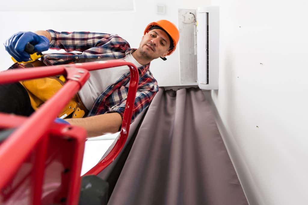 image of ac repair man on ladder performing emergency ac repair for senior home in florida
