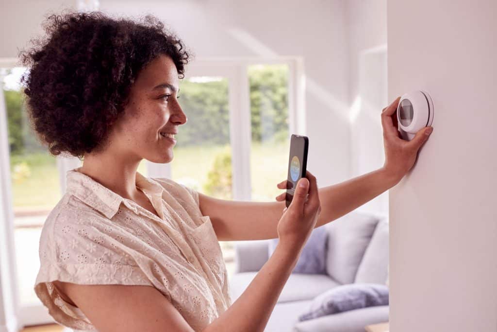 image of woman choosing her smart thermostats settings
